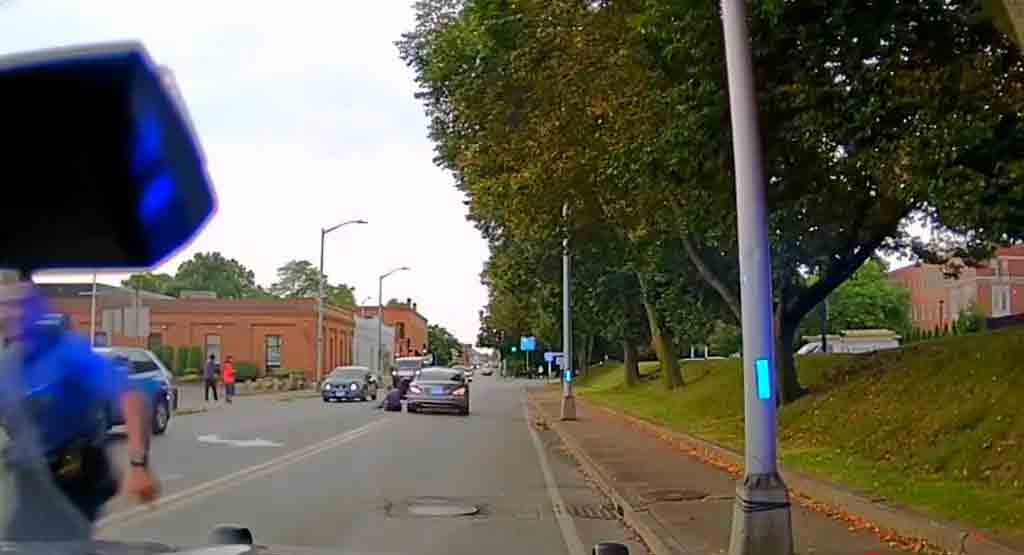 Chokerende video viser politibetjent blive trukket hen ad en travl gade af en flygtende bilist