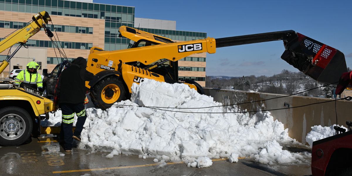 Excavator is removed from the top of parking garage after nearly falling from the last floor